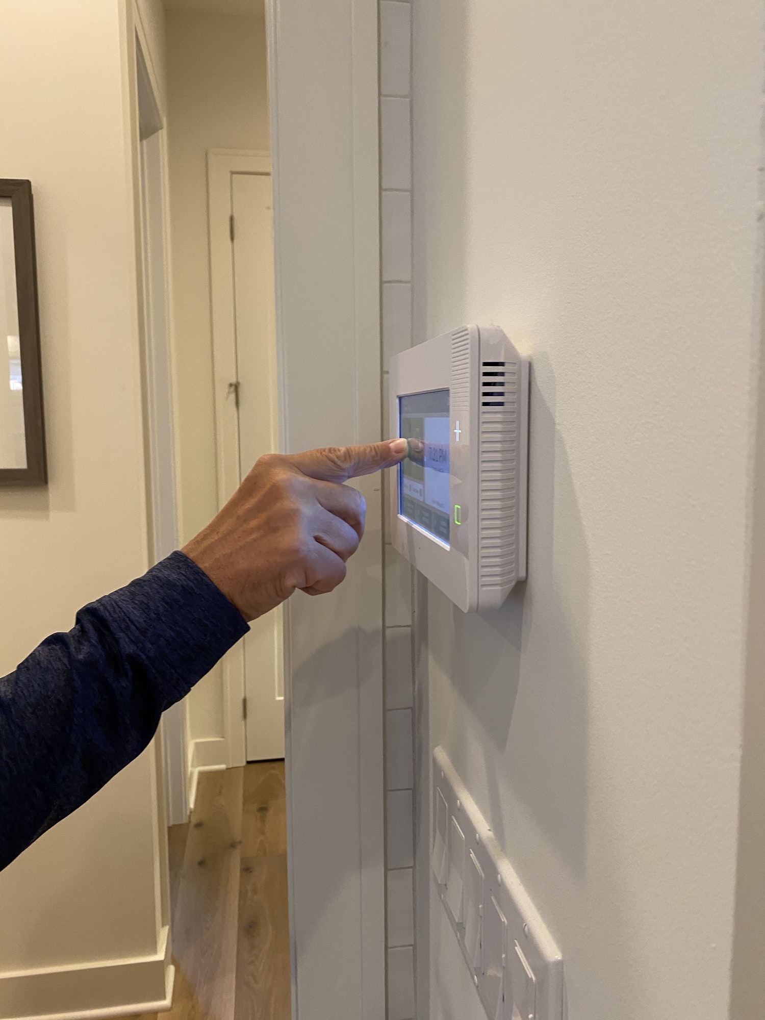 a-man-is-setting-his-alarm-on-a-security-panel-in-his-smart-home-.jpg